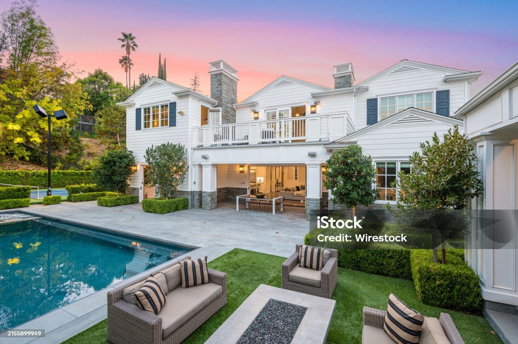 a large pool in front of a white house in encino, california